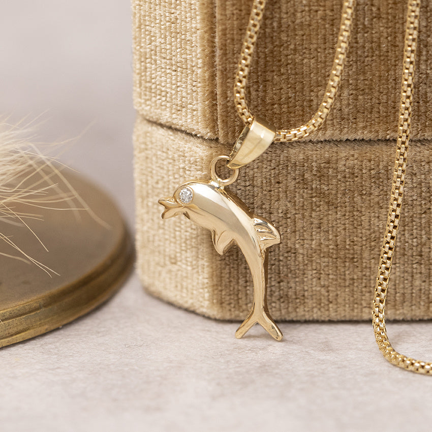 Gold dolphin pendant with 14 karat diamond